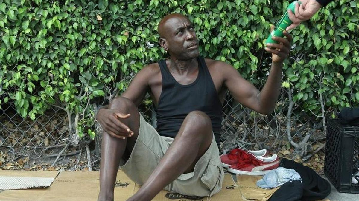 Homeless Lorenzo Ward, 45, is given a can of insect repellent by a Miami police officer in Wynwood. Would you do the same?