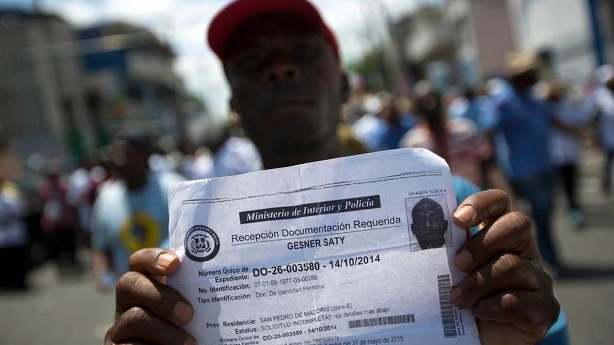 
A deported Haitian man holds up his document that confirms he turned in paperwork to apply for legal residency in the Dominican Republic during a march to the prime minister's office to protest the DR's deportation of Haitians in Port-au-Prince, Haiti on Tuesday.
