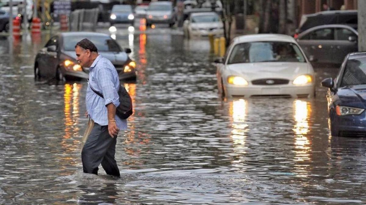 A man and vehicles slosh their way forward in the flooded Brickell area after heavy rains.