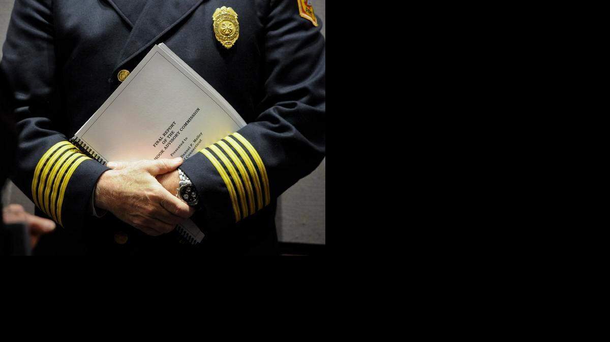 
AFTER SANDY HOOK: Norwalk Fire Chief Denis McCarthy holds a copy of the final report from the Sandy Hook Advisory Commission which made recommendations in the areas of public safety, mental health, and gun-violence prevention after the 2012 killings of 20 first-graders and six adults in Connecticut.
