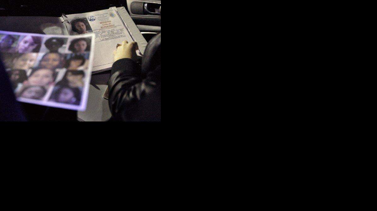 
A staffer from Kristi House, with a photographs of missing girls, prepares to walk the streets of Miami with a team in an effort to thwart sex trafficking.
