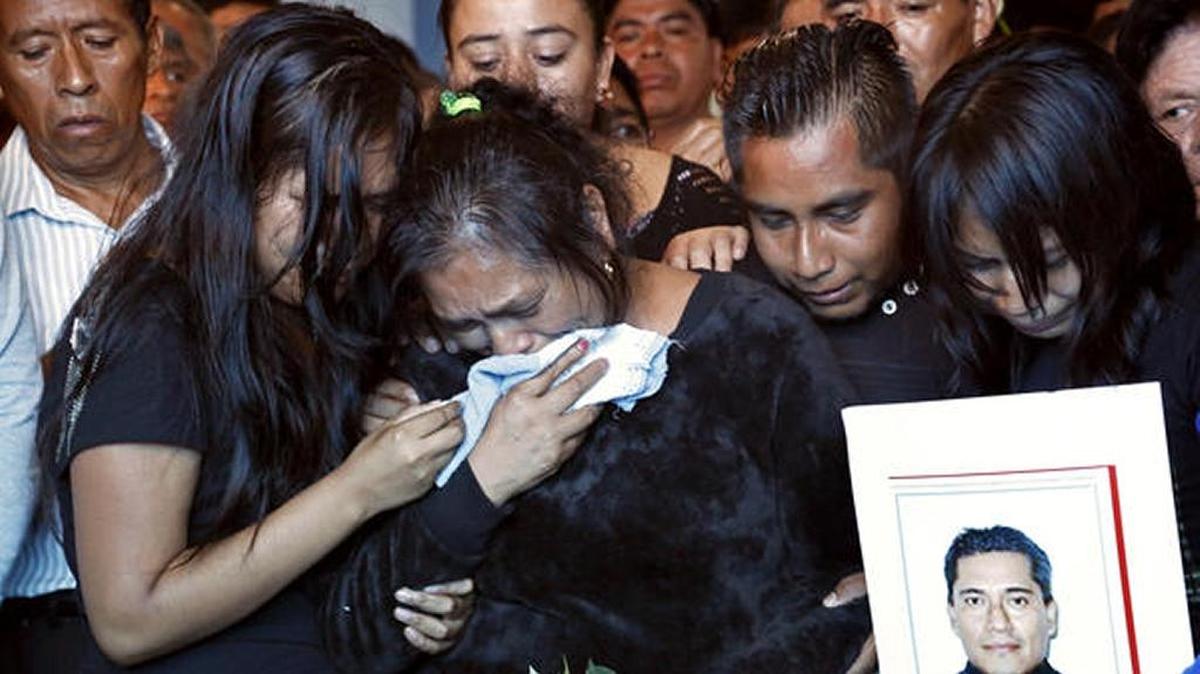 Relatives of slain Rev. Jose Alfredo Suarez de la Cruz grieve as his casket is lowered into the floor inside Our Lady of Asuncion Church in Mexico’s troubled Veracruz state.