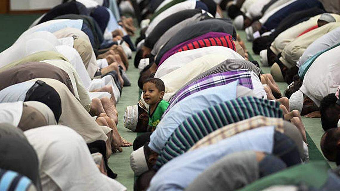 In this 2011 file photo, Hyder Huzri waits as his father and others pray during Ramadan at the Islamic Center of Greater Miami.