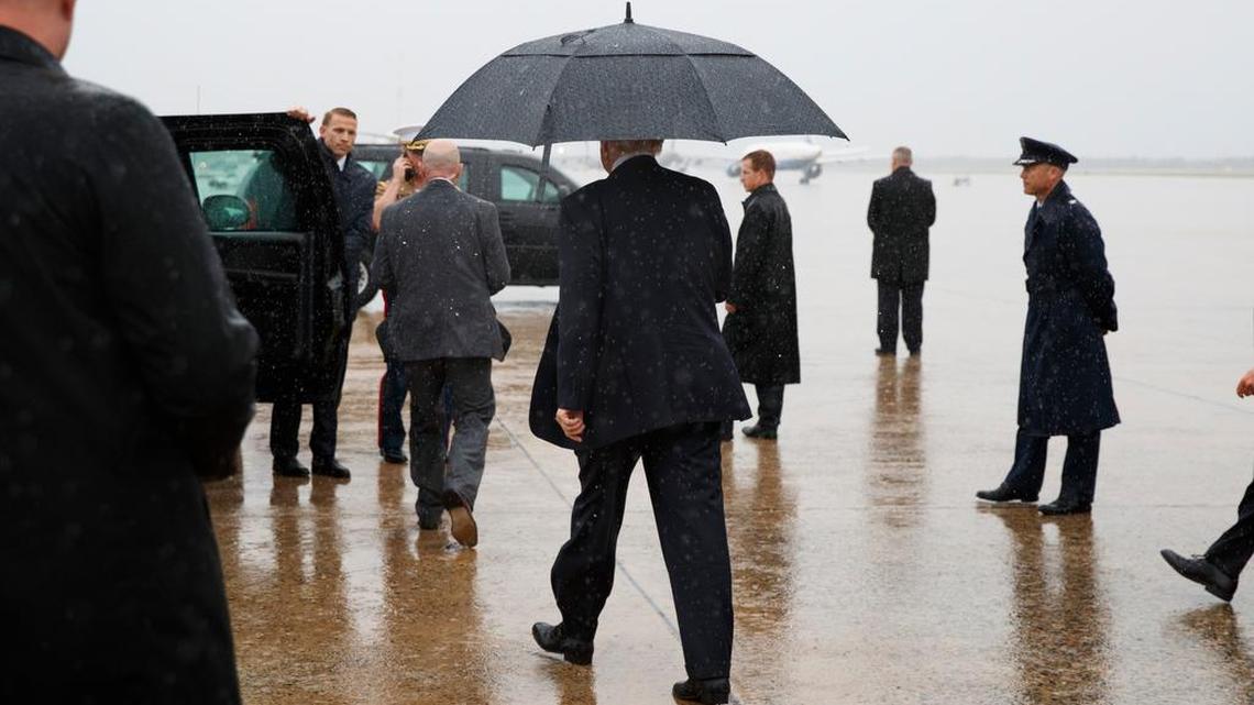 President Trump on Friday walks in the rain to his vehicle after telling reporters of his new chief of staff to replace Reince Priebus.