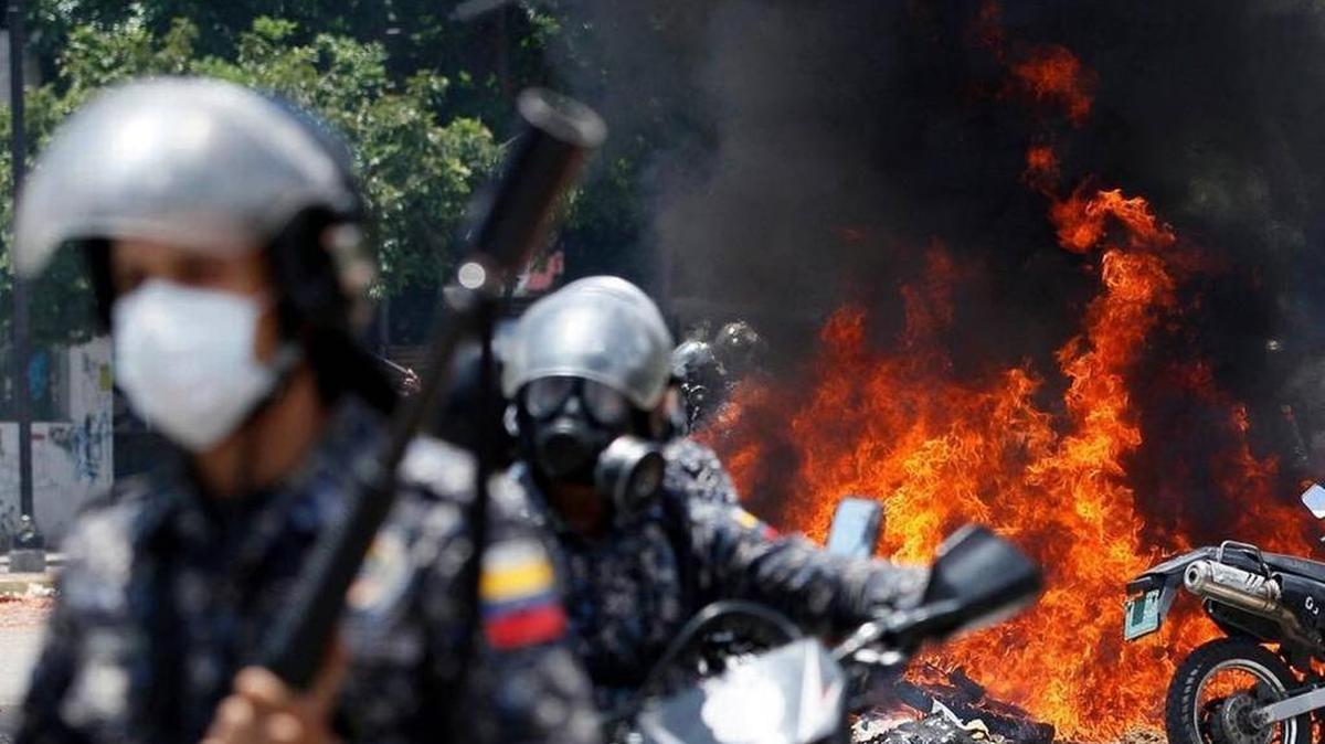 Venezuelan national police retreat after an explosion during clashes with anti-government demonstrators on Sunday.