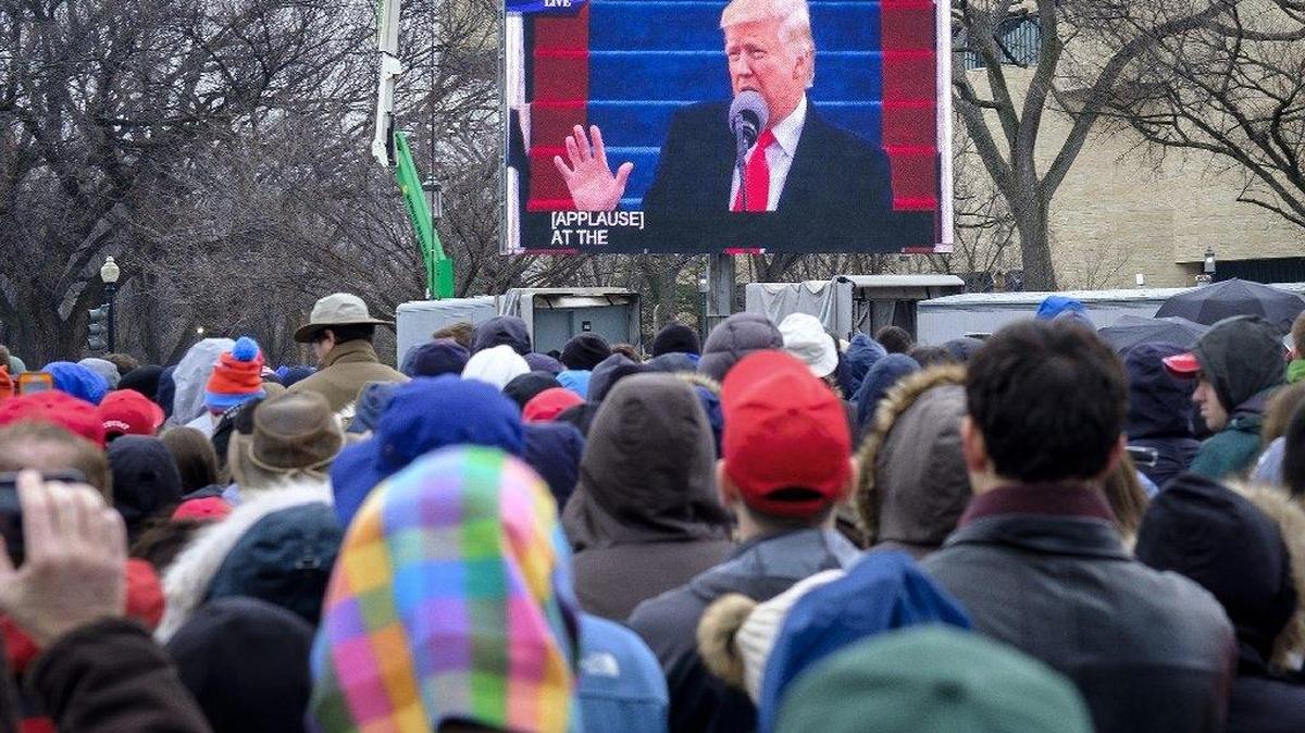 President Donald Trump is seen on a screen as inauguration attendees listen at the National Mall in Washington, D.C.
