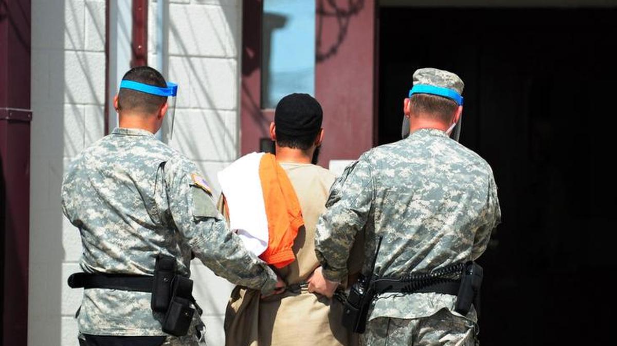 Guards at Guantánamo escort a detainee to Camp 5. Recent rule changes on media access will make the site less transparent.