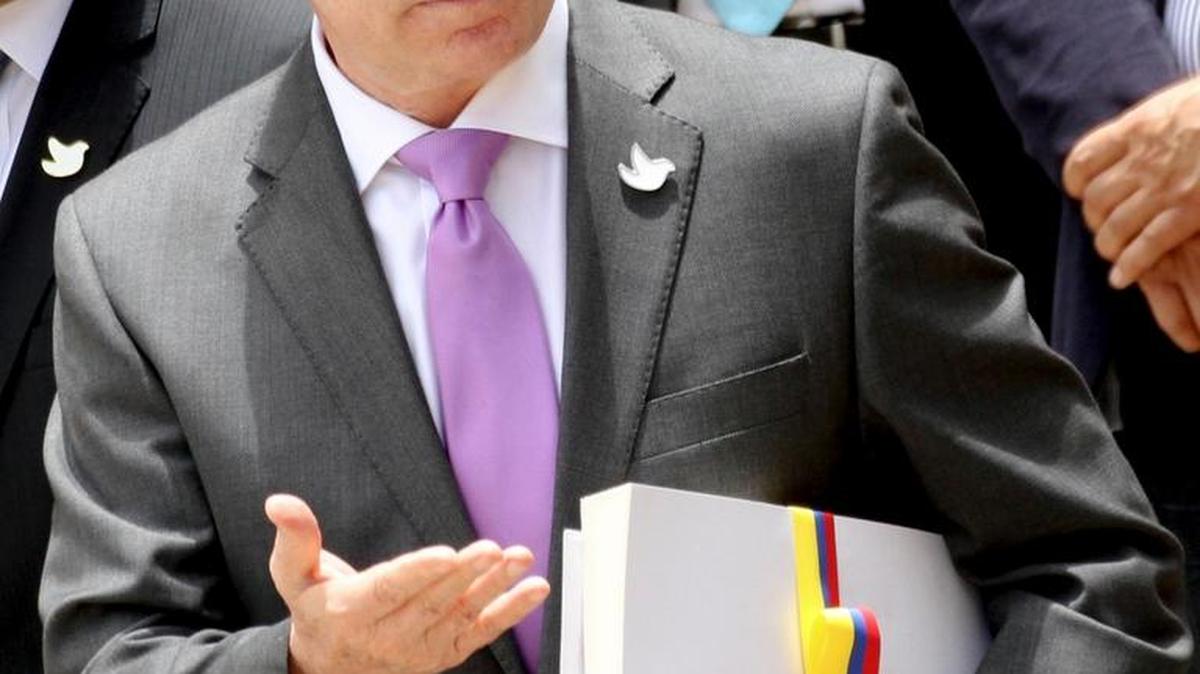 Colombian President Juan Manuel Santos holds the peace deal with rebels after delivering a copy to Colombia’s Congress on Thursday.