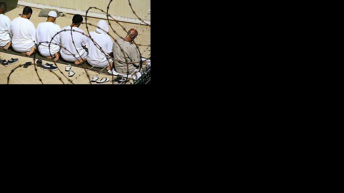 
AT PRAYER: Detainees kneeling at Guantánamo.
