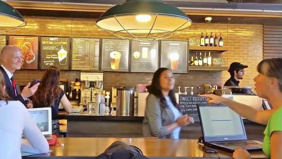 Cara Jennings, right, confronts Gov. Rick Scott at a Gainesville Starbucks.
