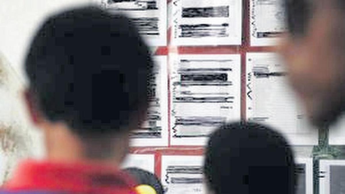 Migrants seeking asylum in the U.S. check their names on a printed list that’s posted at the U.S. Mexico border.