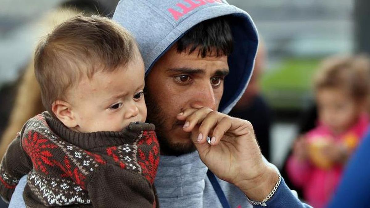 
IN AUSTRIA: A man with a small child arrives with other migrants arrive at the Westbahnhof station in Vienna.
