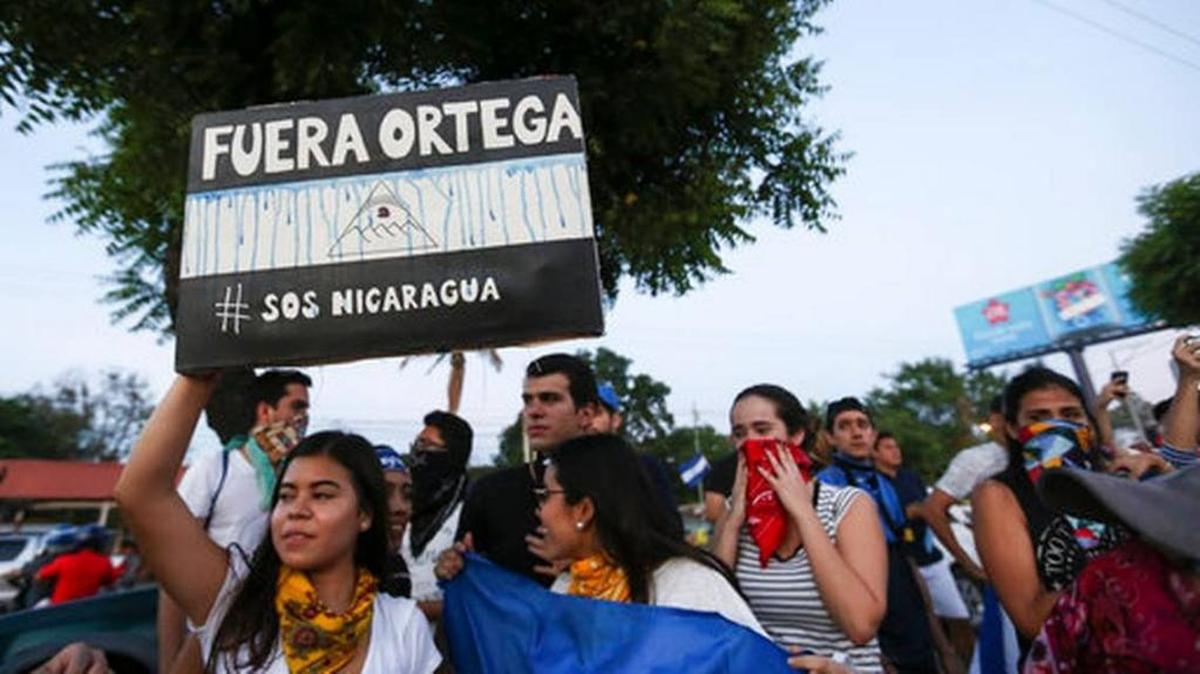 A woman holds a sign that reads in Spanish “Ortega Out,” during a protest against the government of President Daniel Ortega.