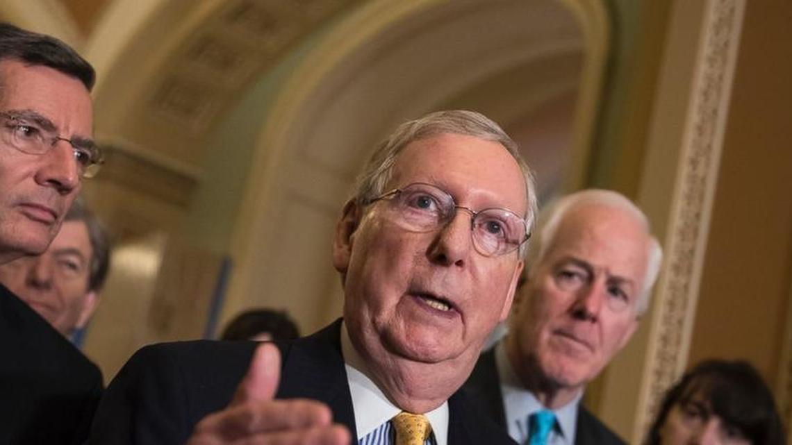 Senate Majority Leader Mitch McConnell, flanked by Sen. John Barrasso, left, and Majority Whip John Cornyn, talk to reporters this month about their healthcare bill.
