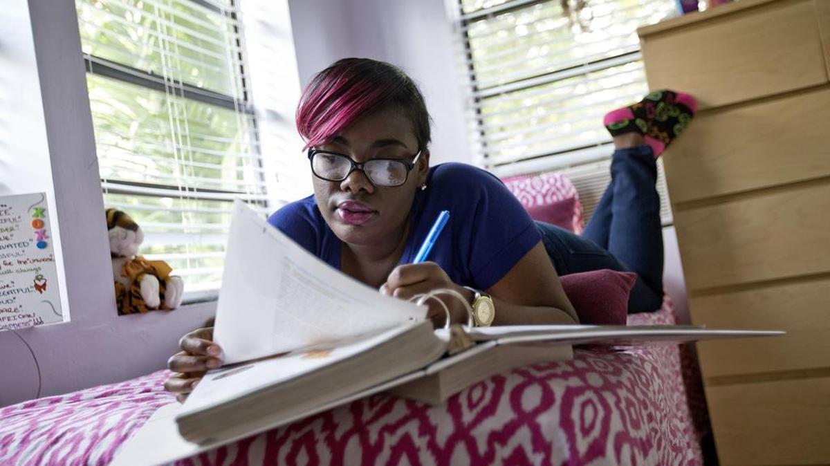 Colesha Courmier, 20, studying in her tiny apartment, is aging out of foster care.