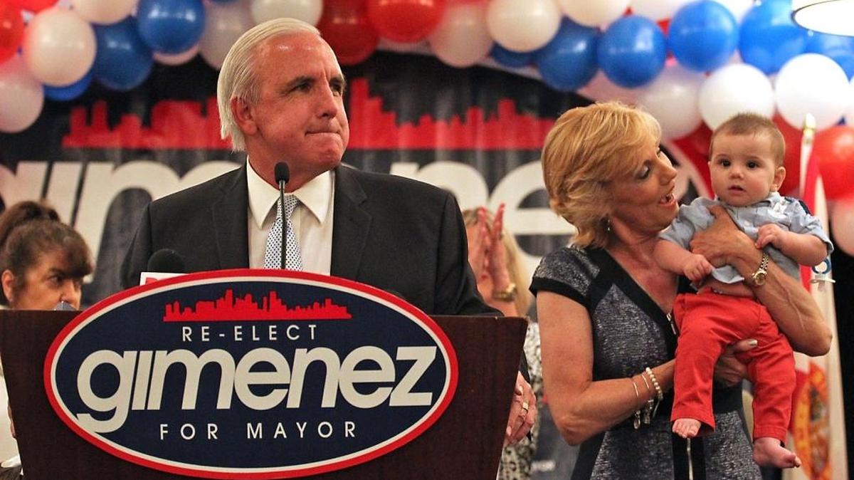 Miami-Dade Mayor Carlos Gimenez takes the stage Tuesday night with his wife, Lourdes, and grandson Michael Gimenez Gato.