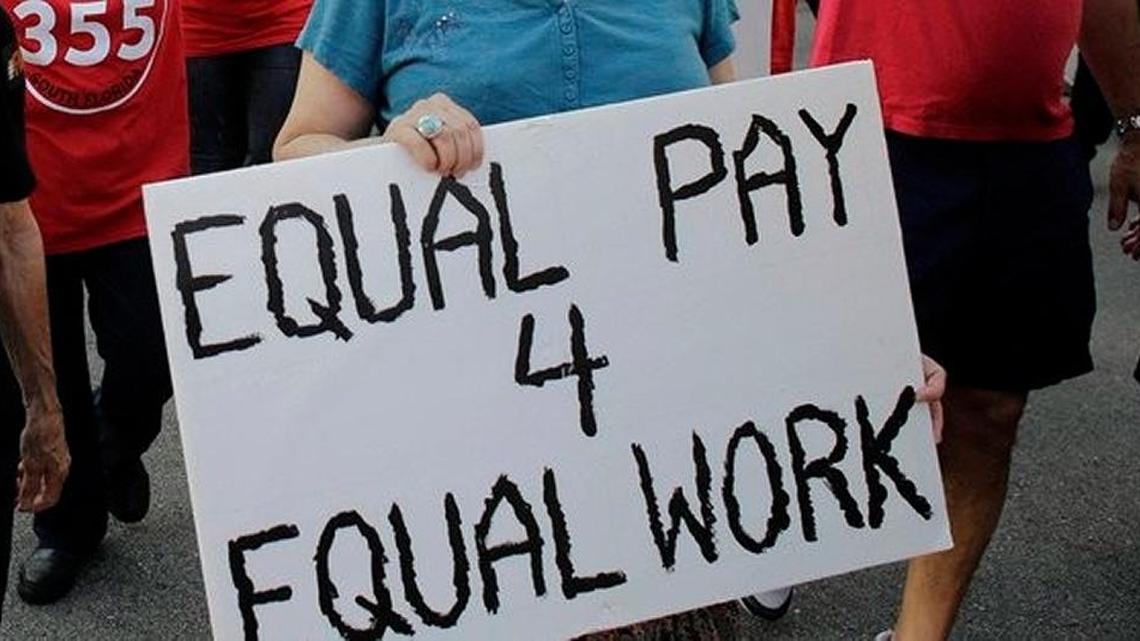 Women send a message during a march on Equal Pay Day in April.