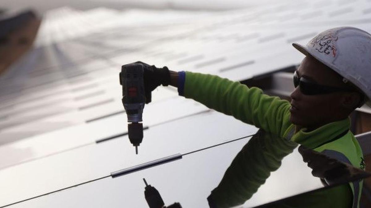 Worker installs solar panels. In Florida, a ballot amendment would give property owners tax exemptions for installation.
