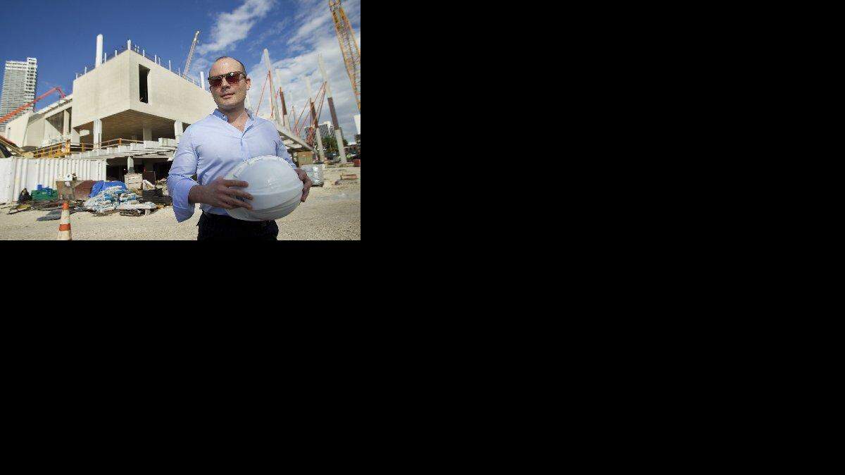
Thom Collins prepares to don a hardhat while on the construction site of the new art museum in 2012. 
