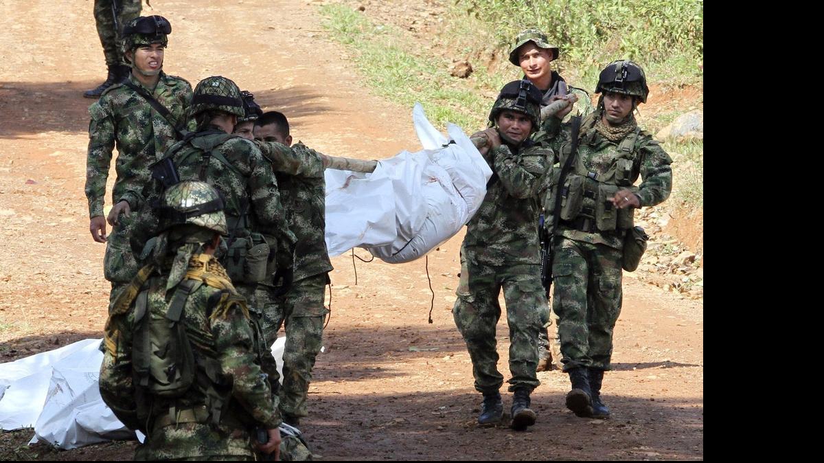 
CASUALTY: Colombian soldiers carry the corpse of one of ten soldiers killed by FARC guerrillas in an ambush in mid-March.
