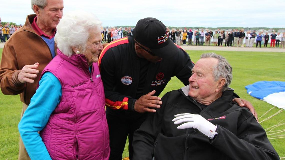 Former President George H.W. Bush is congratulated following a parachute jump in 2014.