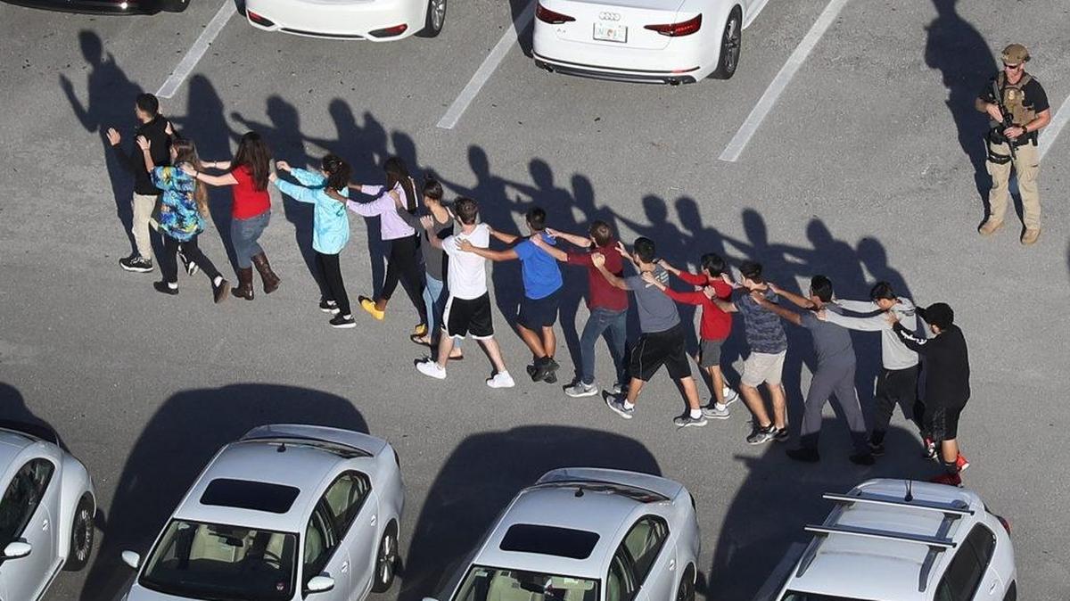 People are brought out of Marjory Stoneman Douglas High School after a mass shooting on Feb. 14, 2018 in Parkland.