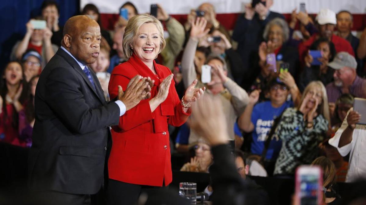 Hillary Clinton campaigns alongside Rep. John Lewis, D-Ga., at a rally in Las Vegas this week. Some question whether she should stay in the race.