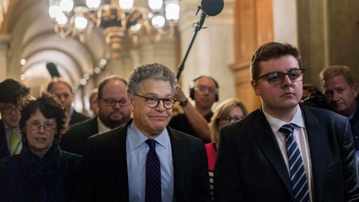 Sen. Al Franken, D-Minn, and his wife, maneuver through the media after he delivered his resignation speech on the Senate floor on Thursday.