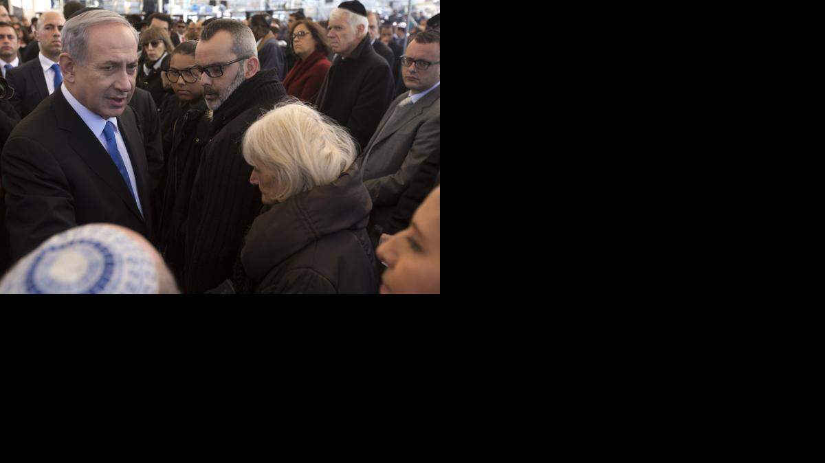 
FUNERAL IN JERUSALEM: Israeli Prime Minister Benjamin Netanyahu speaks with relatives of Yoav Hattab, one of four French Jews killed in a terror attack on a kosher grocery store in Paris. Thousands of mourners joined the families of the victims in the funeral procession. 

