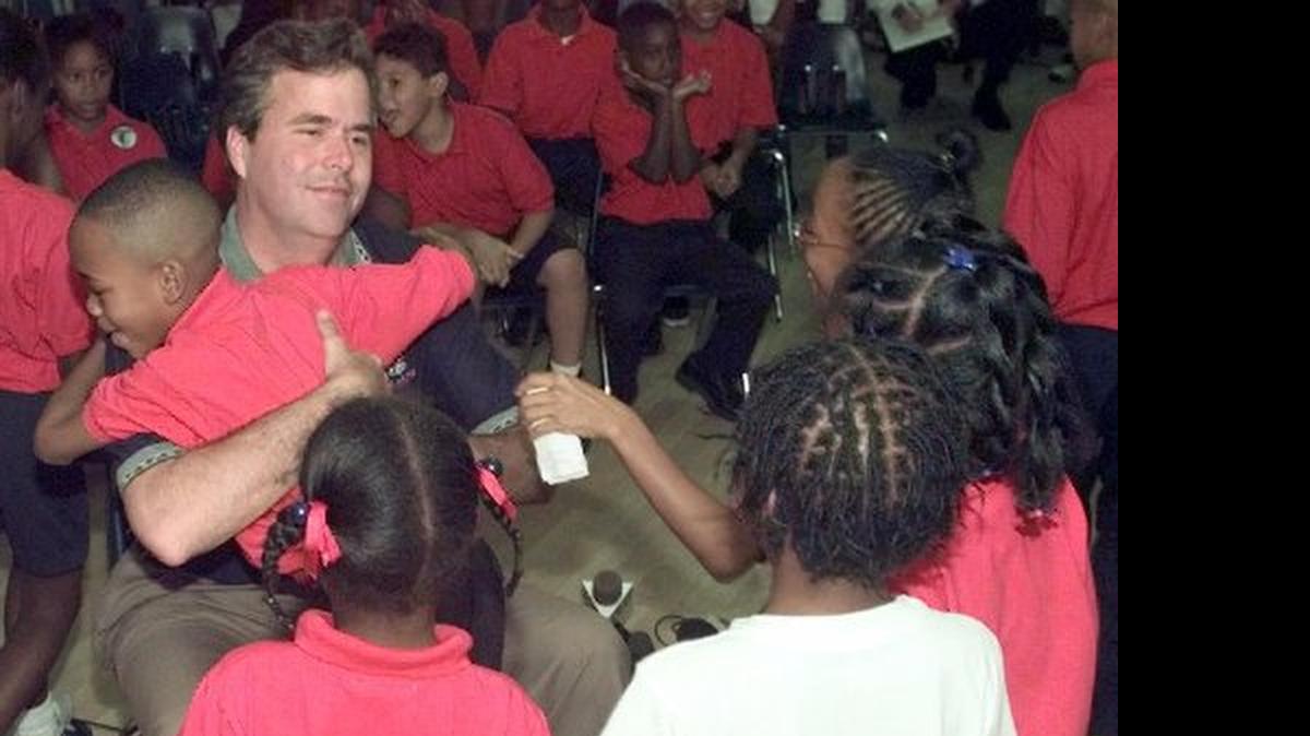 
HUG FOR THE GOV: In 1998, Jeb Bush, then governor-elect, visited students at the Liberty City Charter School, which he co-founded. The school eventually closed.
