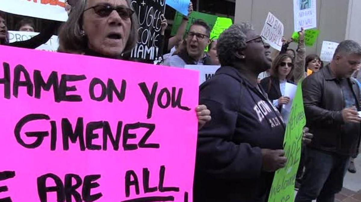 Protesters upset with Miami-Dade Mayor Carlos Gimenez demand he reverse his order to cooperate with federal immigration authorities.