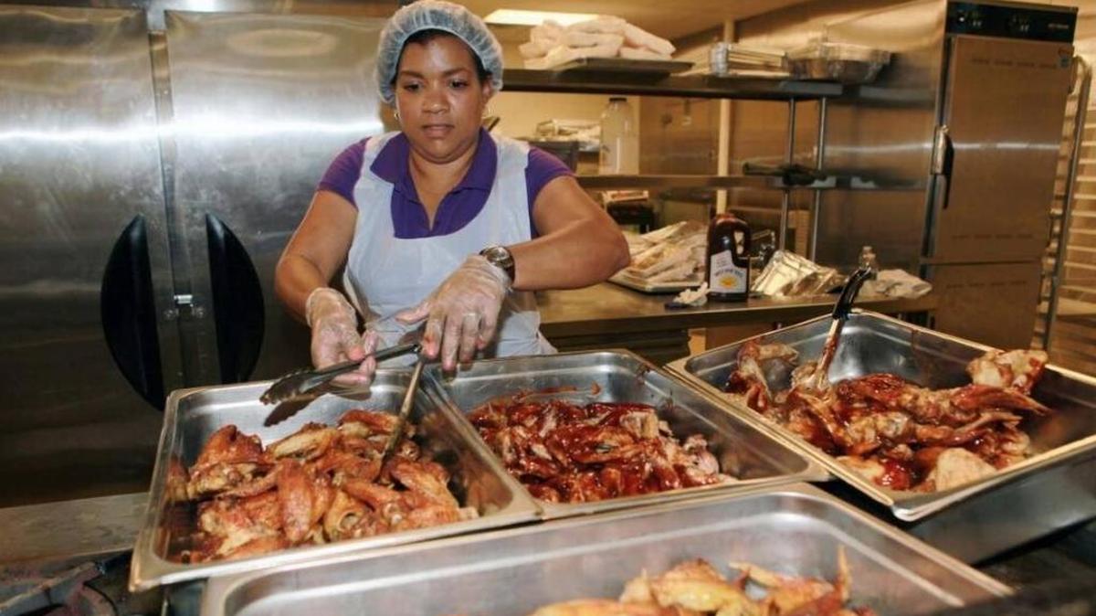 A volunteer helps prepare food at Camillus House, which receives grants from Bank of America.