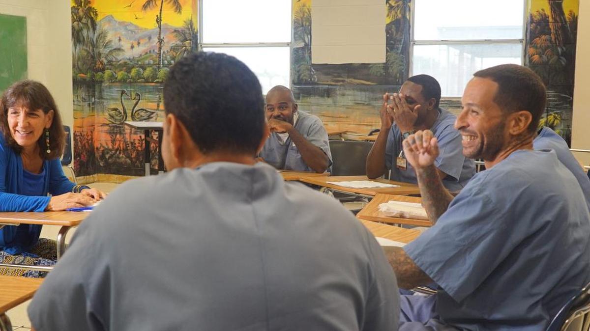 Kathie Klarreich, left, shares a laugh with inmates taking part in the O, Miami poetry celebration. To find out more about View-Through go to: www.viewthrough.miami or www.exchange-for-change.org.