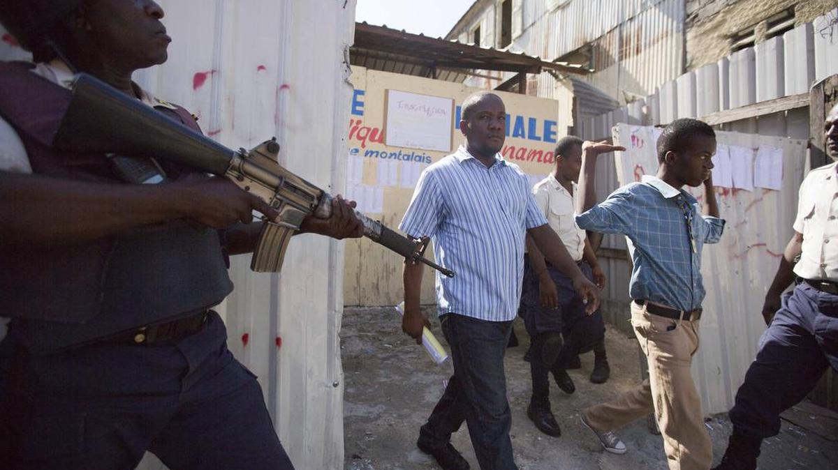 
TROUBLE AT THE POLLS: People are escorted out of a voting center after it was closed because of violence during parliamentary elections in Port-au-Prince, Haiti on Aug. 9.
