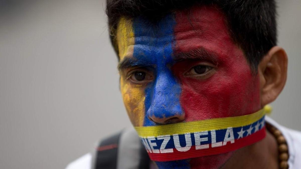 An activist wears a gag in the colors of Venezuela’s flag to protest his government's crackdown.