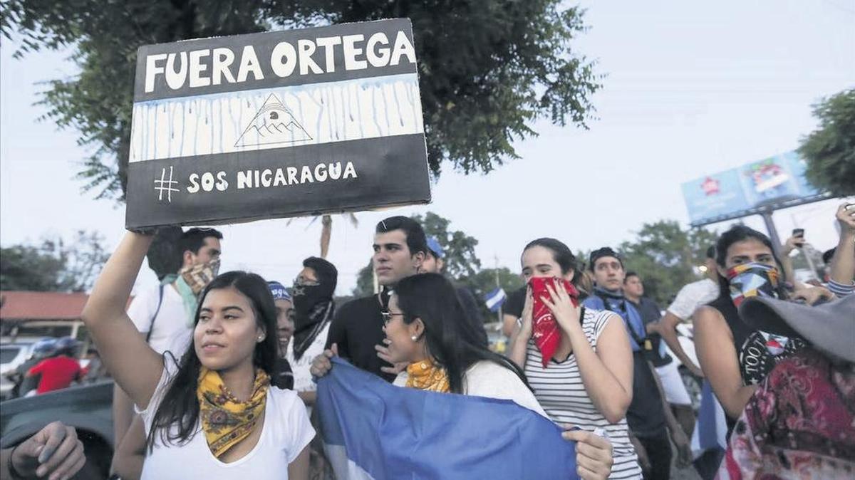 A woman holds a sign that reads in Spanish “Ortega out” during a protest against the government in Managua. Clashes with police have left dozens dead this year.