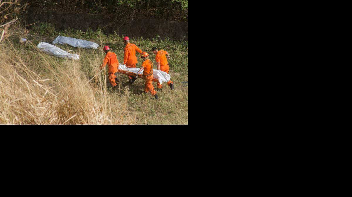 
VIOLENCE CONTINUES: Emergency workers gather bodies last week on the outskirts of San Salvador. The dead are victims of gang violence. 
