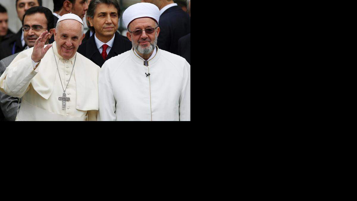 
POPE IN TURKEY: Pope Francis waves to journalists as he stands by Istanbul Mufti Rahmi Yaran during his trip to the Muslim nation last November.
