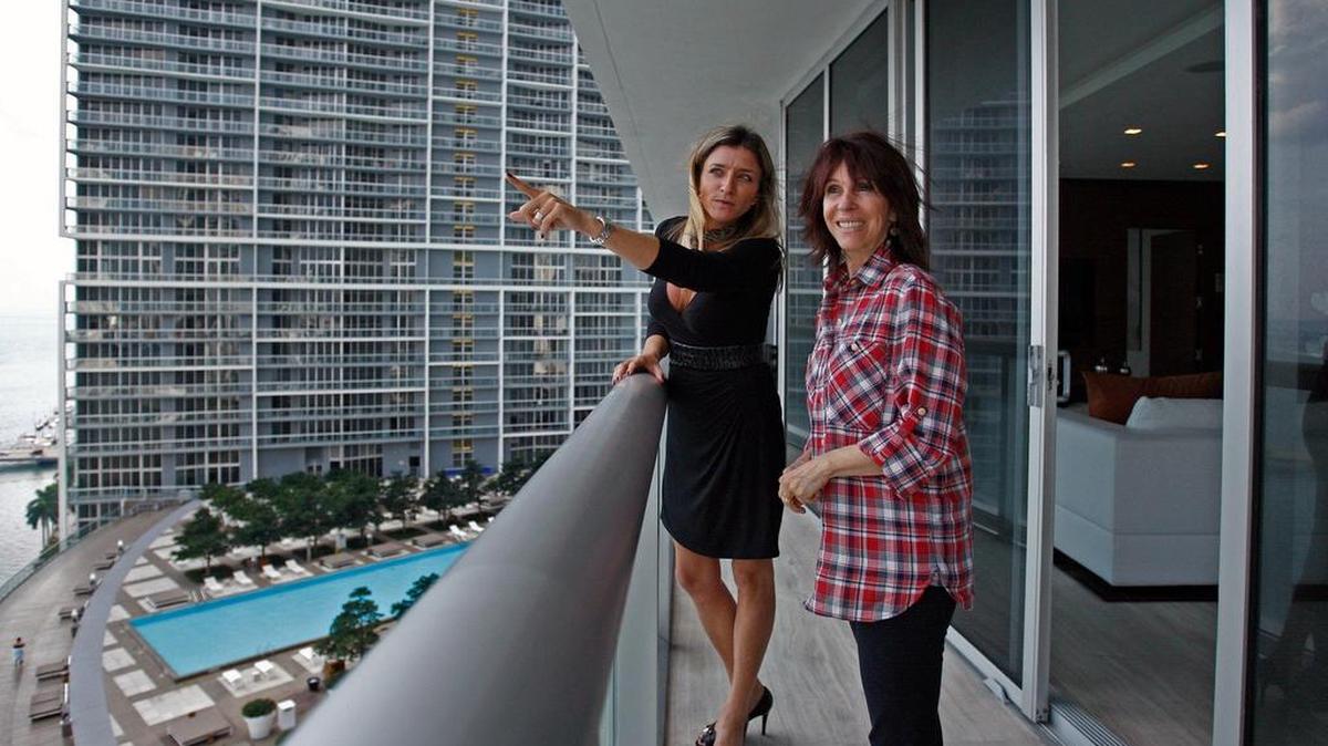 Contributor Lew Sichelman writes that Florida buyers and renters should cement their broker’s role as their fiduciary. Above: Real estate agent Fabiana Pimenta, left, shows Brazilian buyer Maria Helana Abreu a Miami condo in 2015.