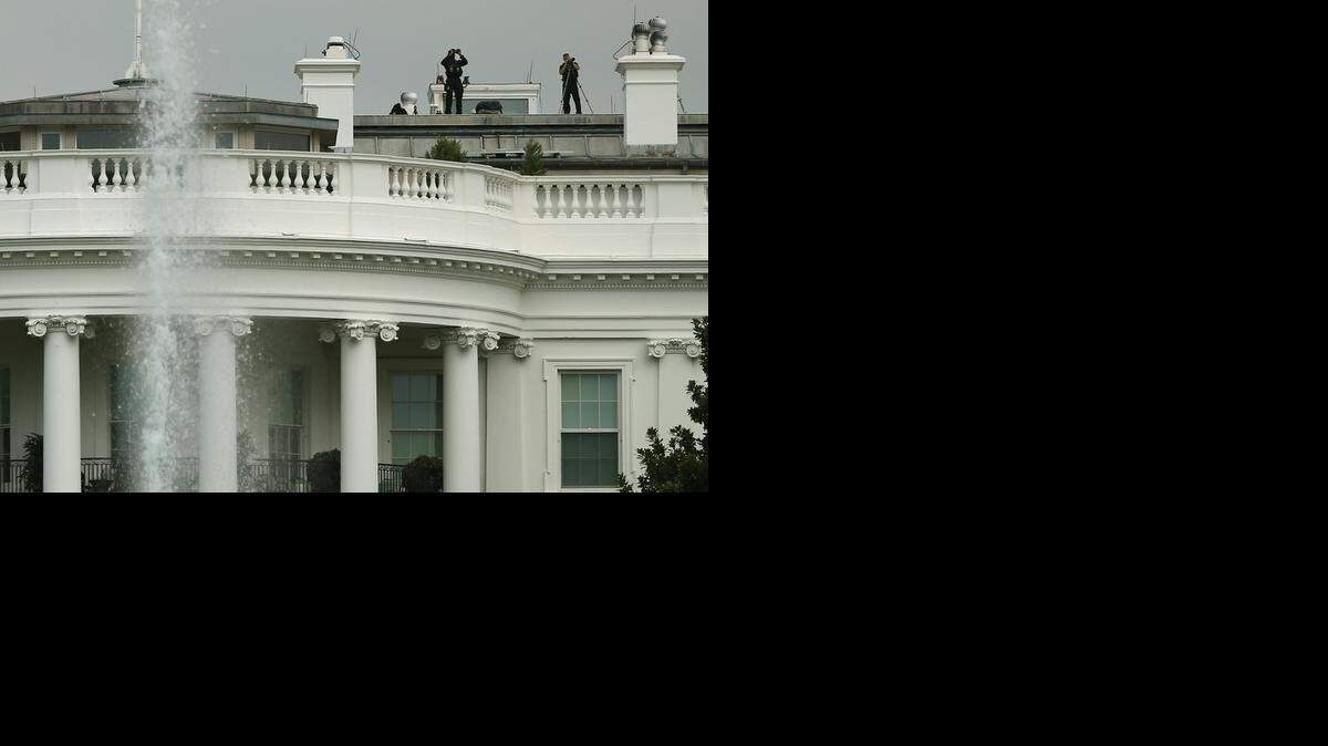 
WHITE HOUSE: Members of the Secret Service stand watch on the roof of the presidential mansion on Tuesday. 
