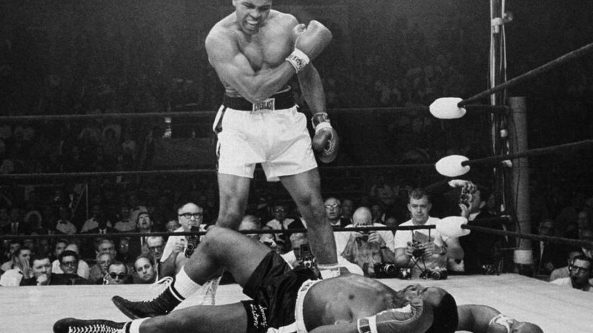 In this May 25, 1965 photo, heavyweight champion Muhammad Ali stands over fallen challenger Sonny Liston, shouting and gesturing shortly after dropping Liston with a short hard right to the jaw in the first round of their title fight in Lewiston, Maine. The bout produced one of the strangest finishes in boxing history as well as one of sports’ most iconic moments.