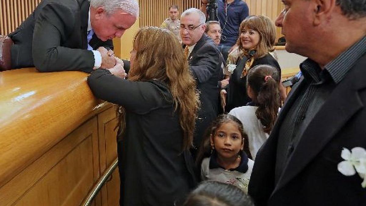 Miami-Dade County Mayor Carlos Gimenez discusses his plan to deal with immigrants with Nora Sandingo as she leaves the Miami-Dade County Commission chambers.