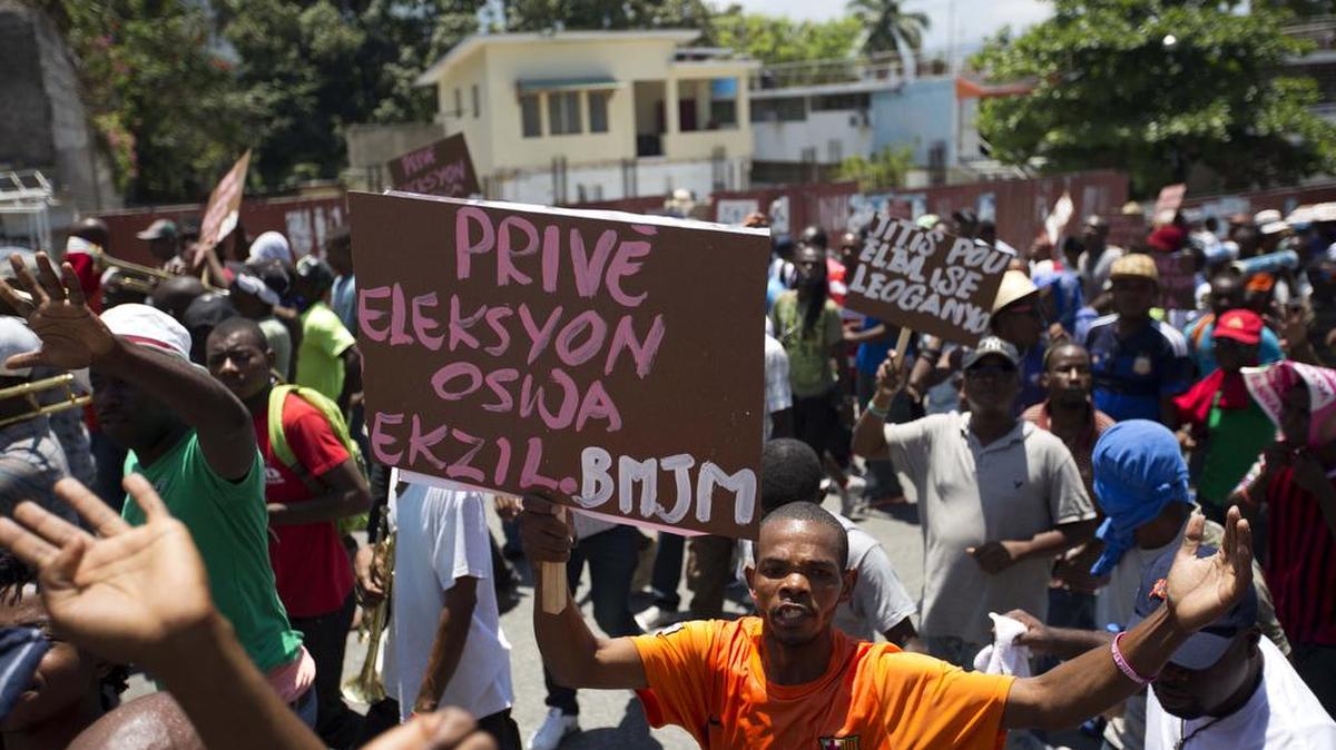 Supporters of Haitian presidential candidate Jovenel Moise hold a demonstration in Port-au-Prince to demand that a final round of voting not be postponed any longer. No date for the election has been set by the interim government.