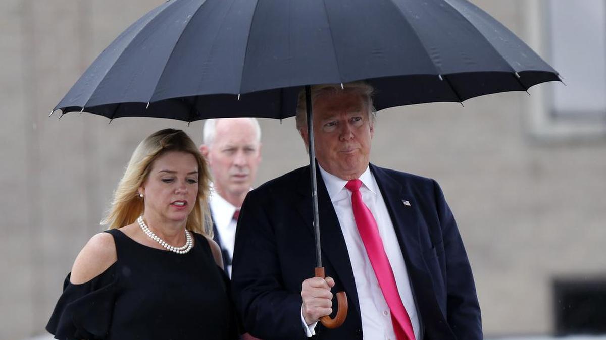 Donald Trump walks in the rain with Florida Attorney General Pam Bondi as they arrive at a campaign rally in Tampa last month.