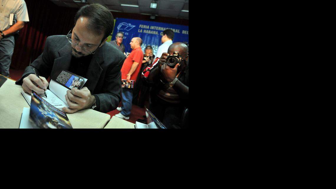 
AUTHOR: Alejandro Castro Espín, son of Raúl Castro, signs a copy of his book, “Imperio del Terror,” during a book fair in Havana in 2009.
