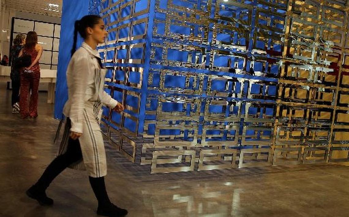 A woman walks past a piece by artists Carla Arocha and Stephane Schraenen at Pinta Miami 2015 art fair in Wynwood.