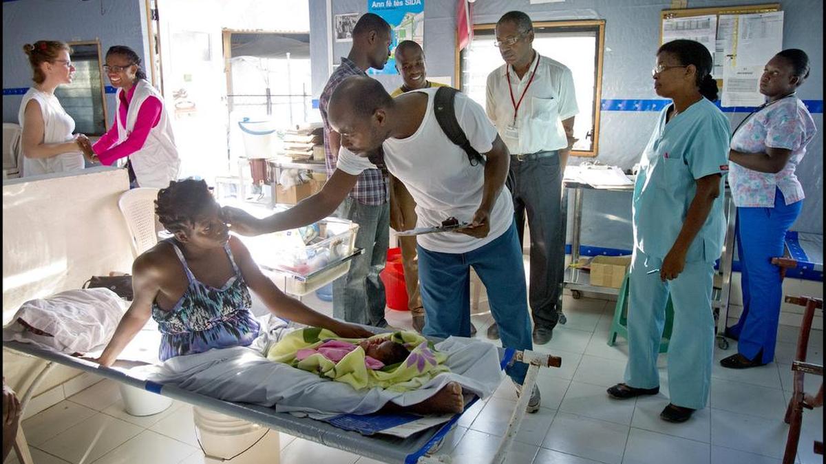Dr. Antonio Jean Baptiste checks on a new mom in the maternal cholera unit while on rounds at a special obstetrics clinic in Port-au-Prince.