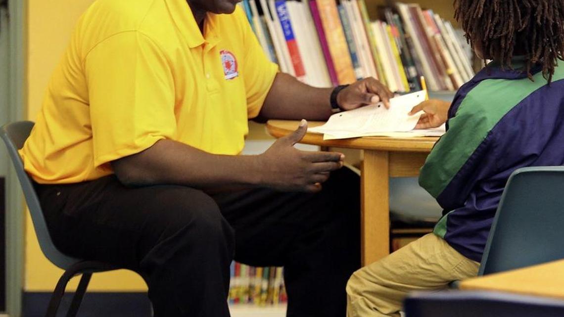In 2015, Maxie Graham, site coordinator at a Success Center in Miami, talks with a student while going over his class assignment.