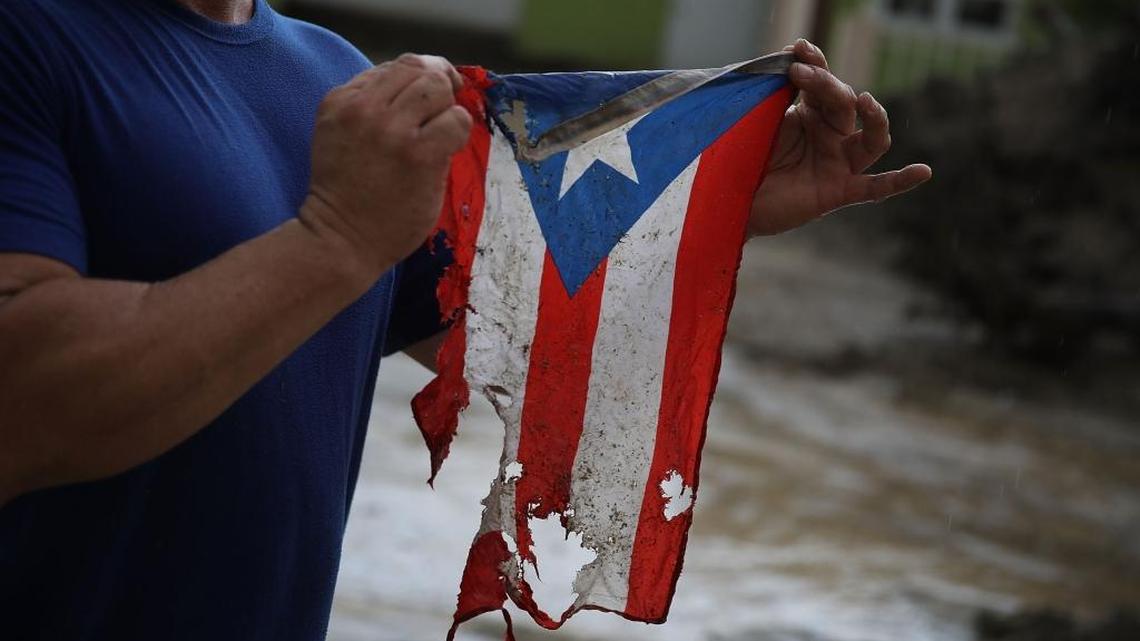 UTUADO, PUERTO RICO - OCTOBER 06:  Jose Javier Santana holds a Puerto Rican flag he found on the ground after Hurricane Maria passed through on October 6, 2017 in Utuado, Puerto Rico.  Mr. Santana said that the flag in its torn and frayed shape is how Puerto Rico is now.  (Photo by Joe Raedle/Getty Images)
