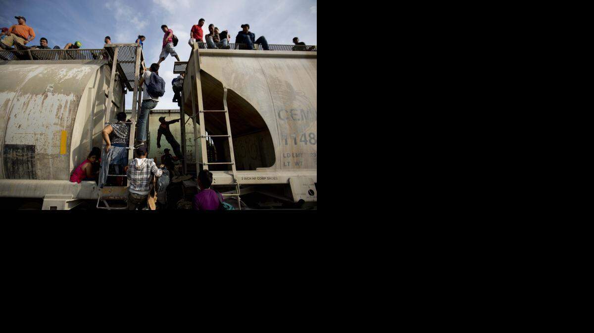
IMMIGRANTS: Central American migrants traveling through Mexico climb on a northbound train during their journey to the U.S. border. 
